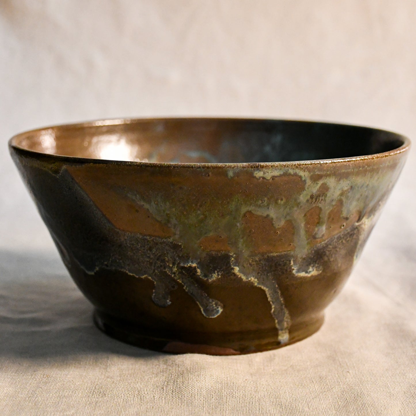 Handmade ceramic serving bowl by Leigh Art featuring Espuela glaze with one-of-a-kind earth-tone movement and wheel-thrown craftsmanship.