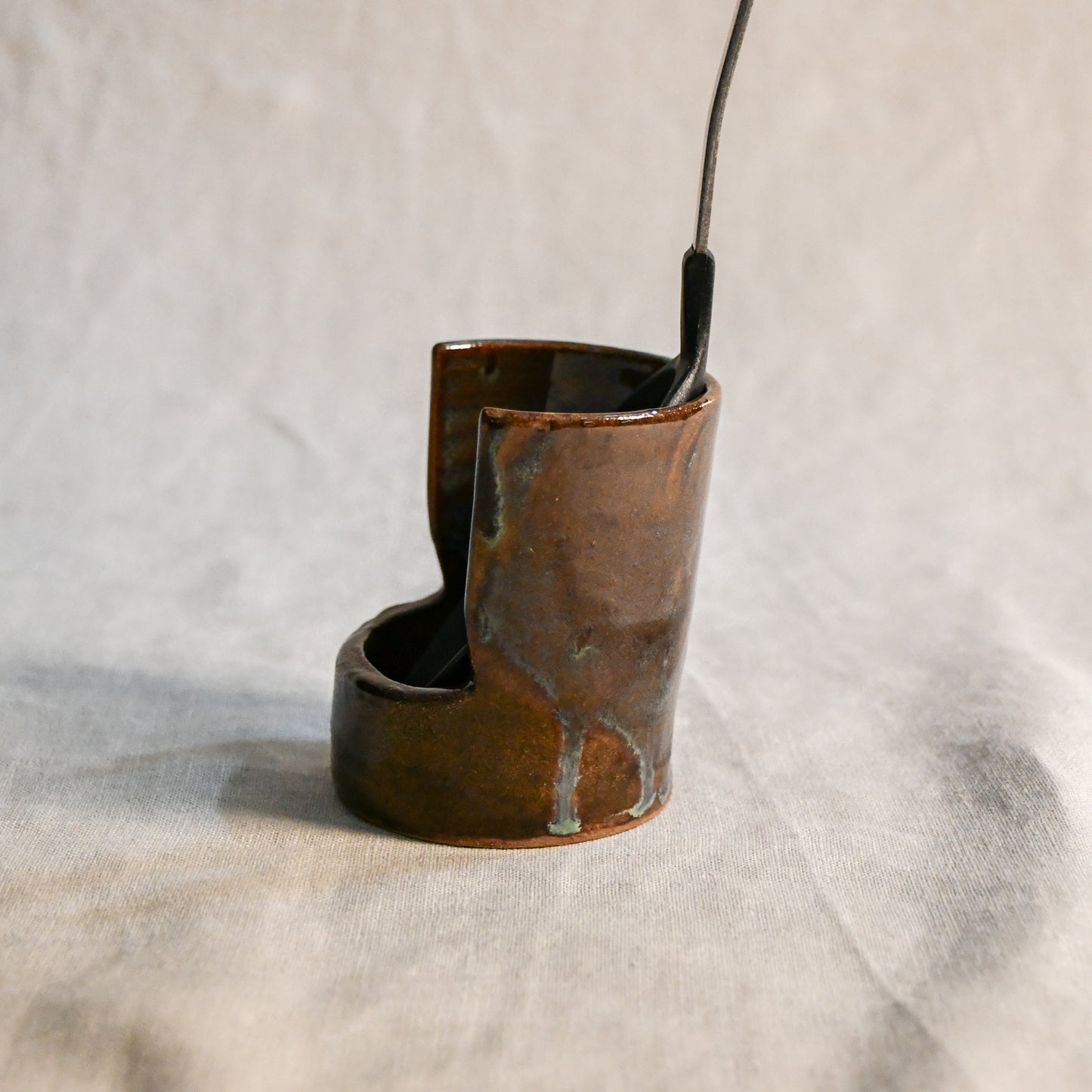 Handmade Espuela ceramic spoon rest by Leigh Art featuring layered earth-tone glaze with organic movement and one-of-a-kind variation.