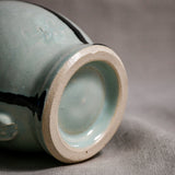 Bottom view close up of pale blue handmade mug showing trimmed fired ceramic foot and texture.