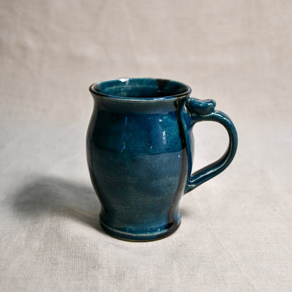 Dark teal handmade pottery mug with black drips from the 5th Buffalo collection by Leigh Art