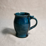 Dark teal handmade pottery mug with black drips from the 5th Buffalo collection by Leigh Art