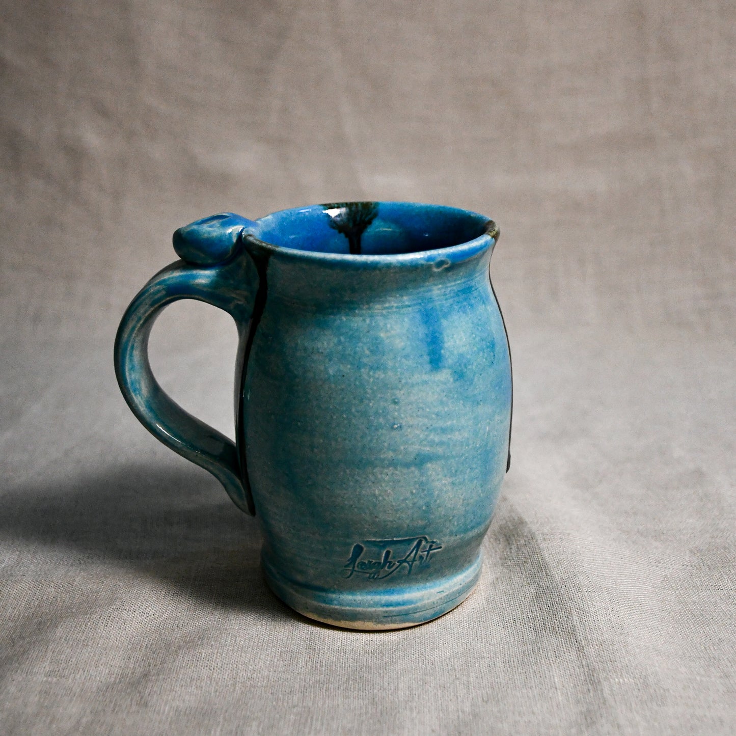 Turquoise handmade pottery mug with black drips from the 5th Buffalo collection by Leigh Art