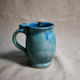 Turquoise handmade pottery mug with black drips from the 5th Buffalo collection by Leigh Art