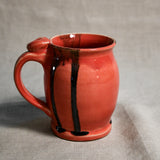 Coral handmade pottery mug with black drips from the 5th Buffalo collection by Leigh Art