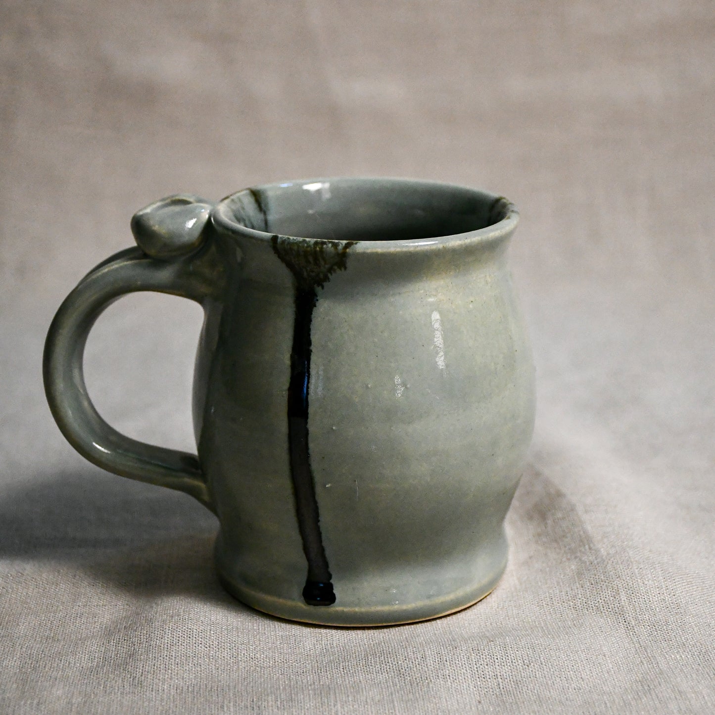 Grey handmade pottery mug with black drips from the 5th Buffalo collection by Leigh Art