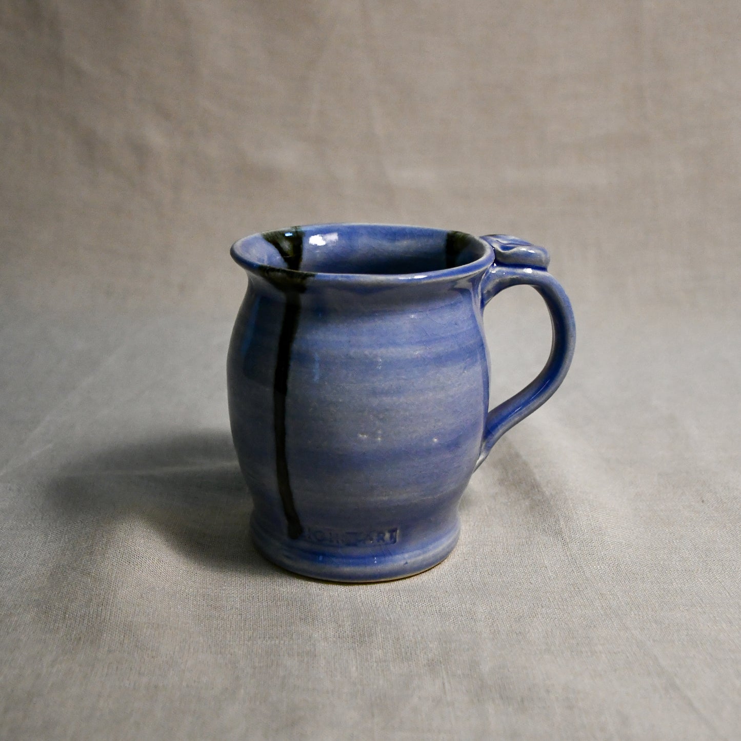 Purple handmade pottery mug with black drips from the 5th Buffalo collection by Leigh Art
