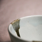 Close up of pale blue handmade wheelthrown pottery salsa bowl from the 5th Buffalo collection by Leigh Art showing black drips and texture. 