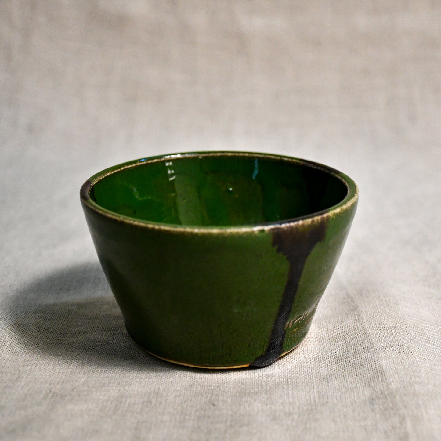 Green handmade wheelthrown salsa bowl with black drips from the 5th Buffalo collection by Leigh Art.