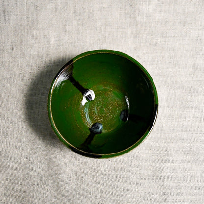Interior image of a green handmade wheelthrown salsa bowl with black drips from the 5th Buffalo collection by Leigh Art.