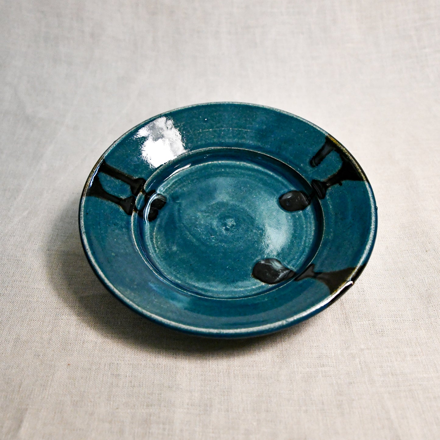 Dark teal handmade wheelthrown pottery saucer from the 5th Buffalo collection by Leigh Art