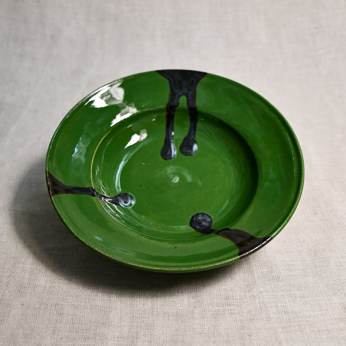 Green handmade wheelthrown pottery saucer from the 5th Buffalo collection by Leigh Art