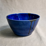 Side view of turquoise handmade wheelthrown serving bowl with black drips from the 5th Buffalo collection from Leigh Art. 