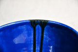Close up of blue handmade wheelthrown serving bowl with black drips from the 5th Buffalo collection from Leigh Art. 