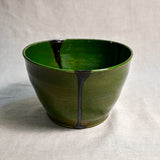 Side view of green handmade wheelthrown serving bowl with black drips from the 5th Buffalo collection from Leigh Art. 