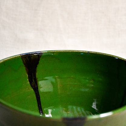 Close up of green handmade wheelthrown serving bowl with black drips from the 5th Buffalo collection from Leigh Art. 
