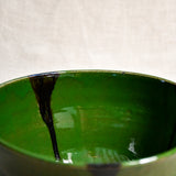 Close up of green handmade wheelthrown serving bowl with black drips from the 5th Buffalo collection from Leigh Art. 