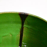 Close up of green handmade wheelthrown serving bowl with black drips and texture from the 5th Buffalo collection from Leigh Art. 