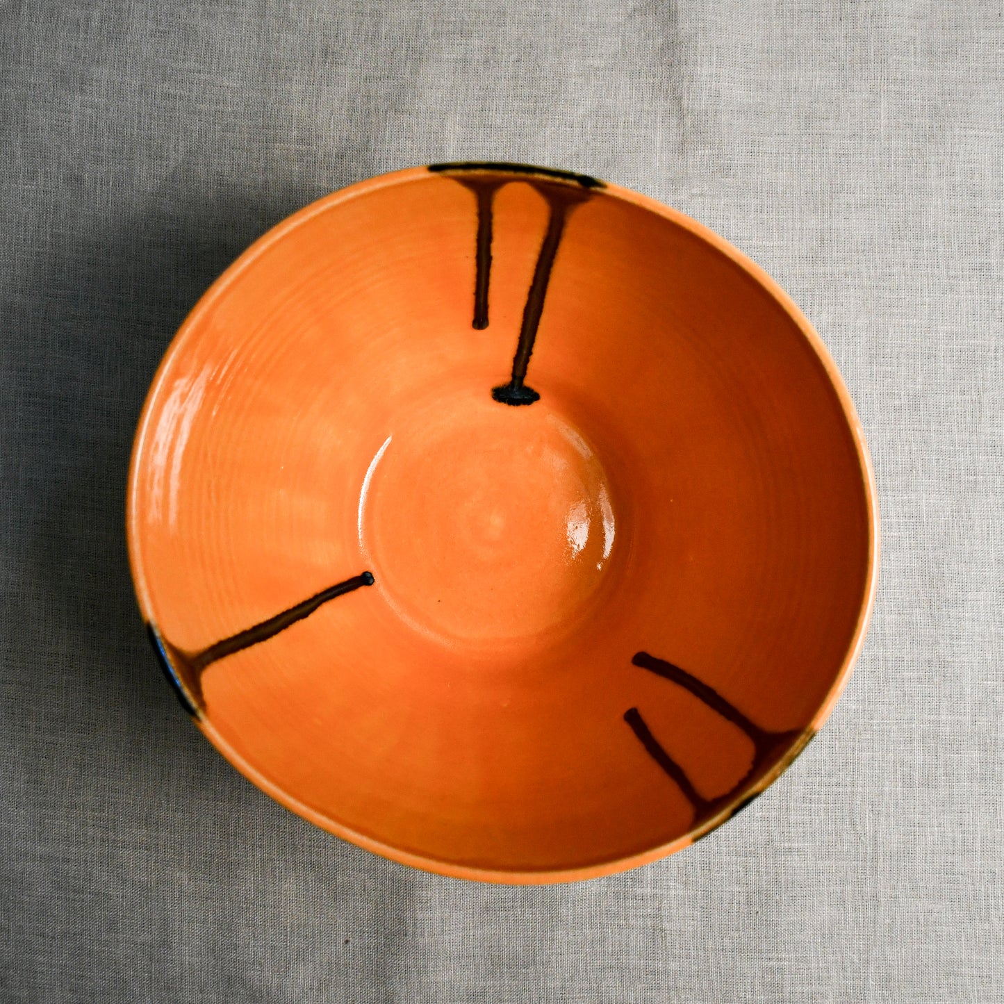 Interior image of a orange handmade wheelthrown serving bowl from the 5th Buffalo collection by Leigh Art.