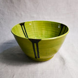 Side view of lime green handmade wheelthrown serving bowl with black drips from the 5th Buffalo collection from Leigh Art. 