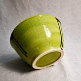 Bottom view of lime green handmade wheelthrown serving bowl with black drips and texture from the 5th Buffalo collection from Leigh Art. 