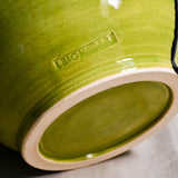 Close up of bottom of lime green handmade wheelthrown serving bowl with black drips and texture from the 5th Buffalo collection from Leigh Art. 