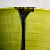 Close up of lime green handmade wheelthrown serving bowl with black drips and texture from the 5th Buffalo collection from Leigh Art. 