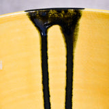 Close up of yellow handmade wheelthrown serving bowl with black drips and crazing from the 5th Buffalo collection from Leigh Art. 