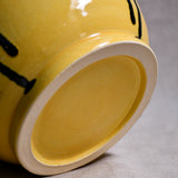 Bottom view of yellow handmade wheelthrown serving bowl with black drips from the 5th Buffalo collection from Leigh Art. 