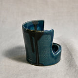Close up of side profile of dark teal vertical handmade pottery spoon rest from the 5th Buffalo collection by Leigh Art with black drips