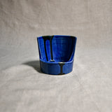 Close up of blue vertical handmade pottery spoon rest from the 5th Buffalo collection by Leigh Art with black drips