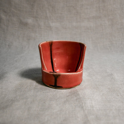 Close up of coral vertical handmade pottery spoon rest from the 5th Buffalo collection by Leigh Art with black drips