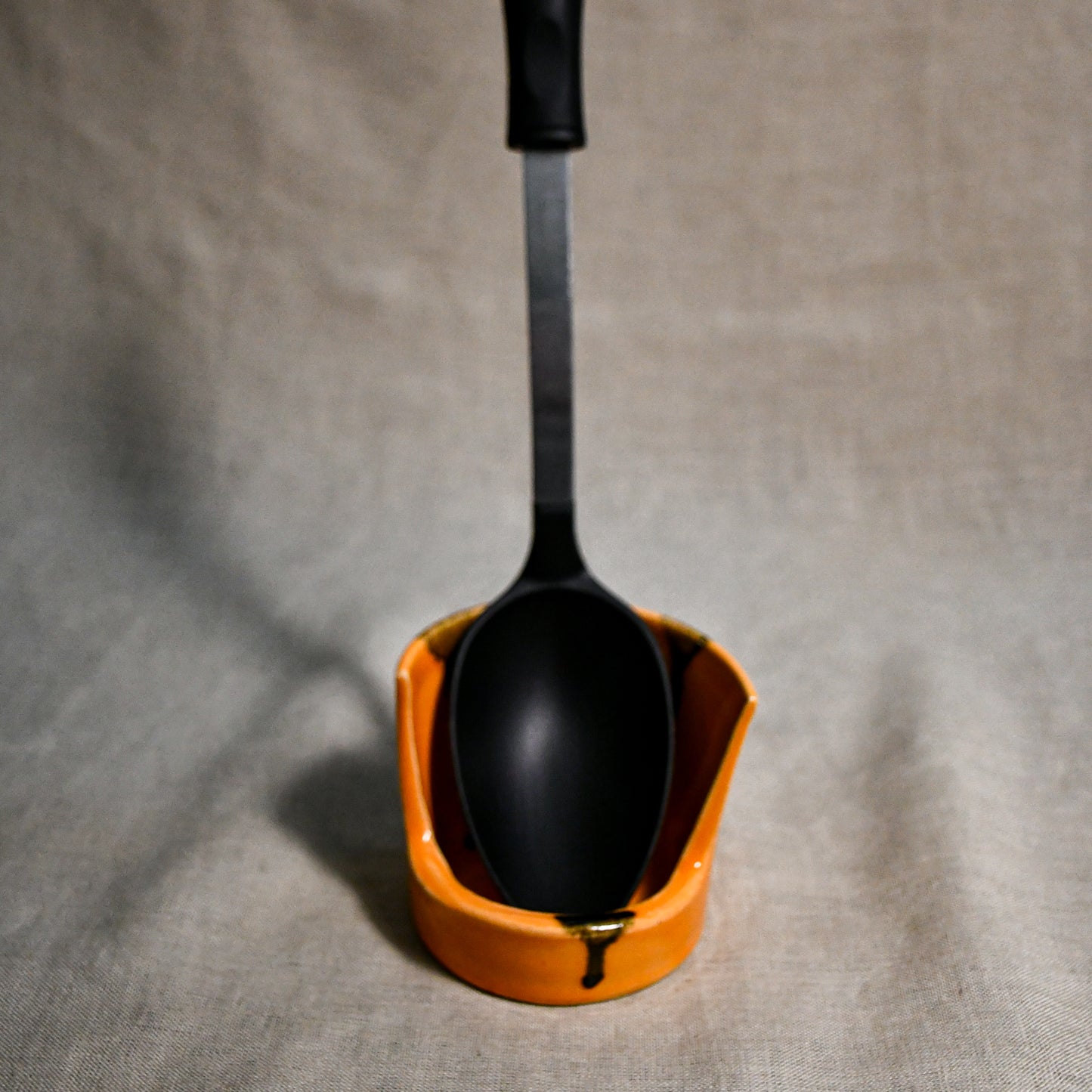 Vertical orange handmade spoon rest with serving spoon from the 5th Buffalo collection by Leigh Art