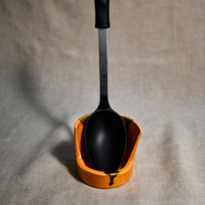 Vertical orange handmade spoon rest with serving spoon from the 5th Buffalo collection by Leigh Art