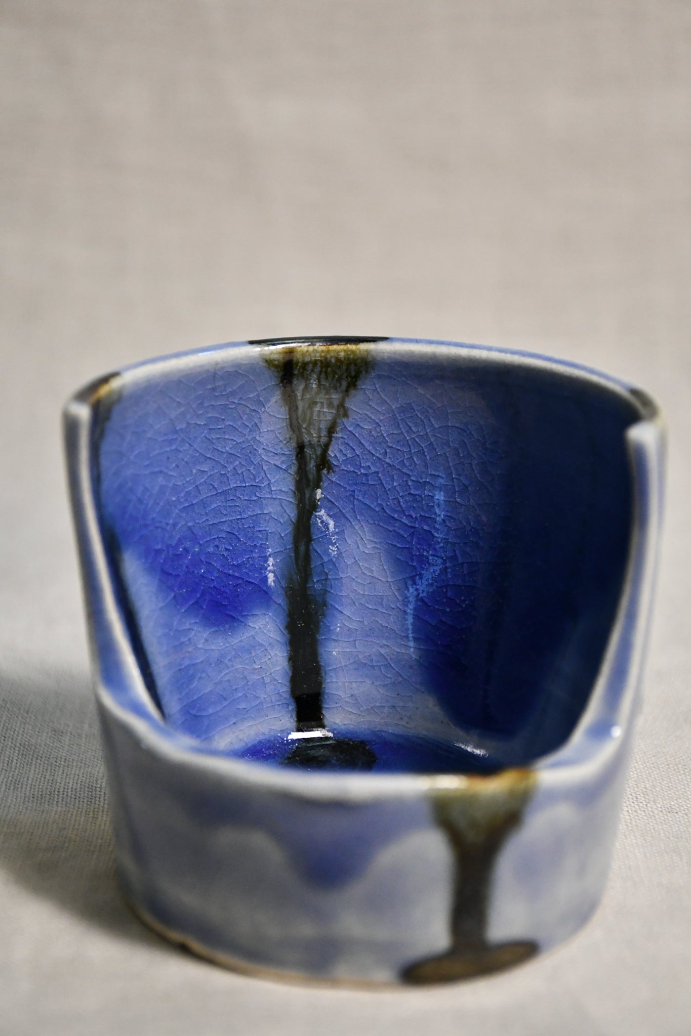 Close up of purple vertical handmade pottery spoon rest from the 5th Buffalo collection by Leigh Art with black drips and crazing