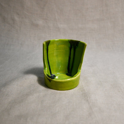 Close up of lime green vertical handmade pottery spoon rest from the 5th Buffalo collection by Leigh Art with black drips