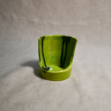 Close up of lime green vertical handmade pottery spoon rest from the 5th Buffalo collection by Leigh Art with black drips