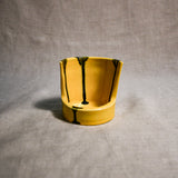 Close up of yellow vertical handmade pottery spoon rest from the 5th Buffalo collection by Leigh Art with black drips 