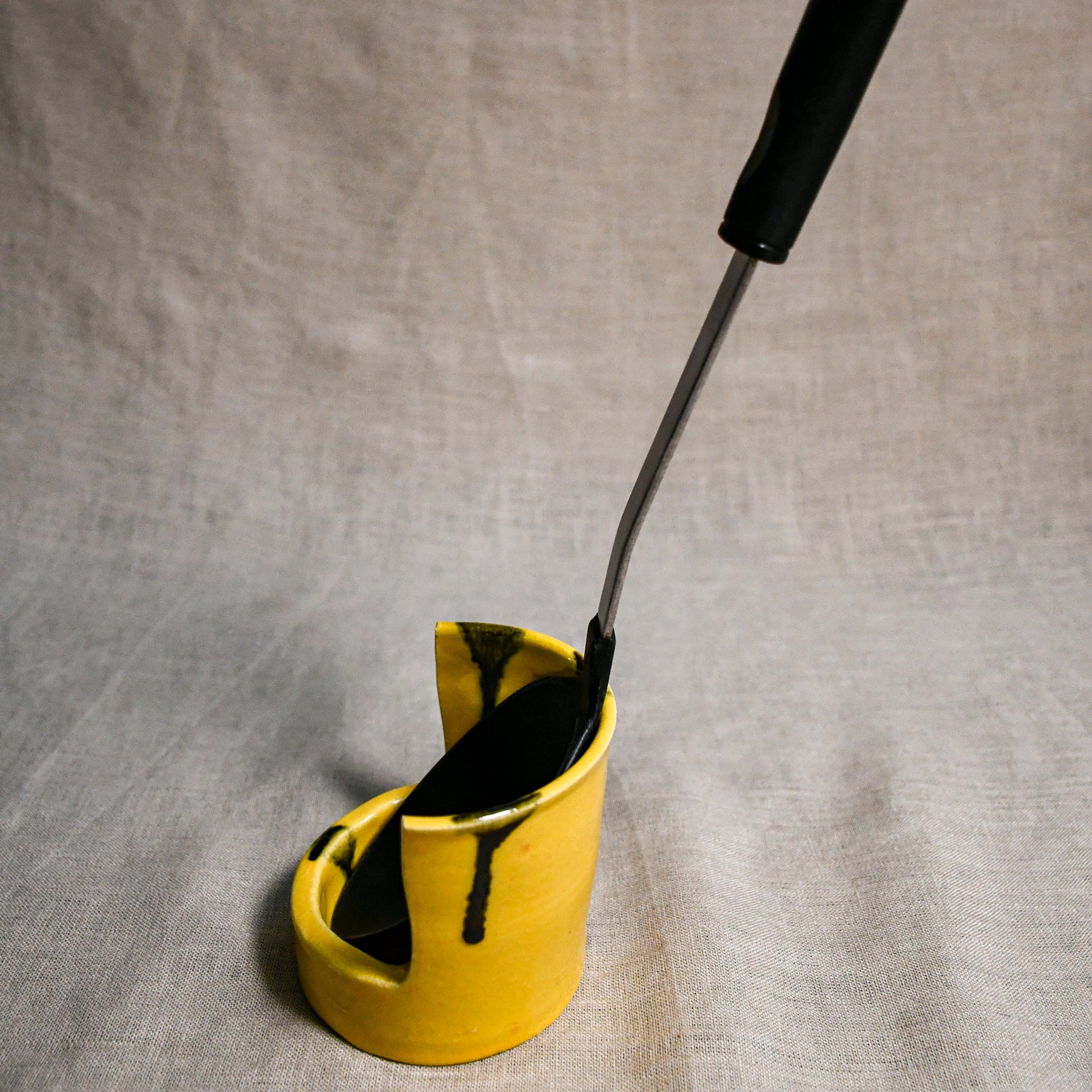 Side profile of vertical yellow handmade spoon rest with serving spoon from the 5th Buffalo collection by Leigh Art