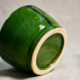 Bottom view of a green ceramic chili bowl showing exposed stoneware clay and texture