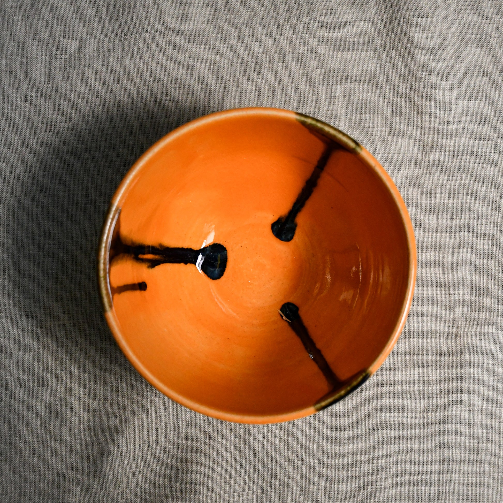 Interior image of an orange handmade wheelthrown chili bowl from the 5th Buffalo collection by Leigh Art.