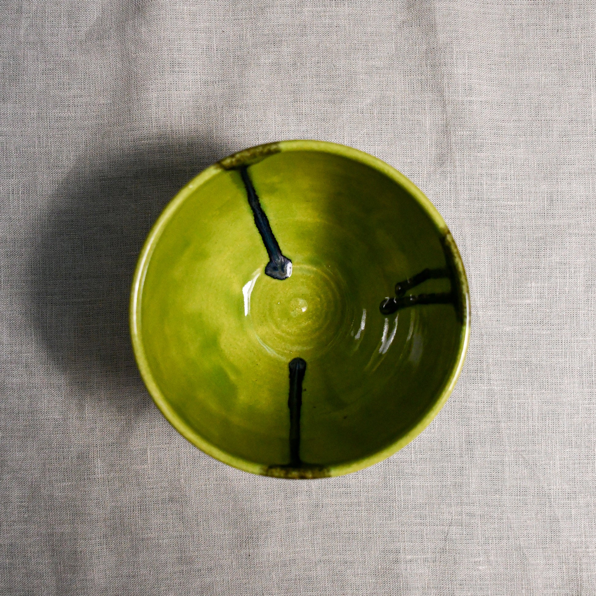 Interior image of a lime green handmade wheelthrown chili bowl from the 5th Buffalo collection by Leigh Art.