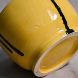 Bottom view of a yellow ceramic chili bowl showing exposed stoneware clay and texture