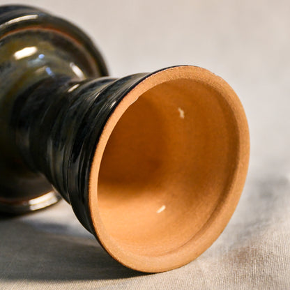 Bottom View: Close-up of the Ancient Jasper glaze on a handmade ceramic candlestick, showcasing layered tones of black, bronze, olive green, and rust with a glossy finish.