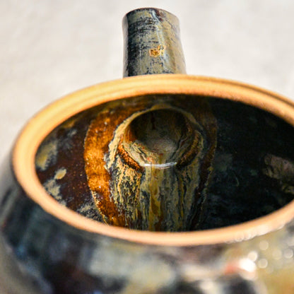 Close-up of the Ancient Jasper glaze on a handmade ceramic teapot, showcasing glossy layers of bronze, olive green, black, and deep rust tones.