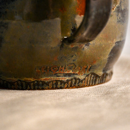 Close-up of the Ancient Jasper glaze on a handmade ceramic teapot, showcasing glossy layers of bronze, olive green, black, and deep rust tones.