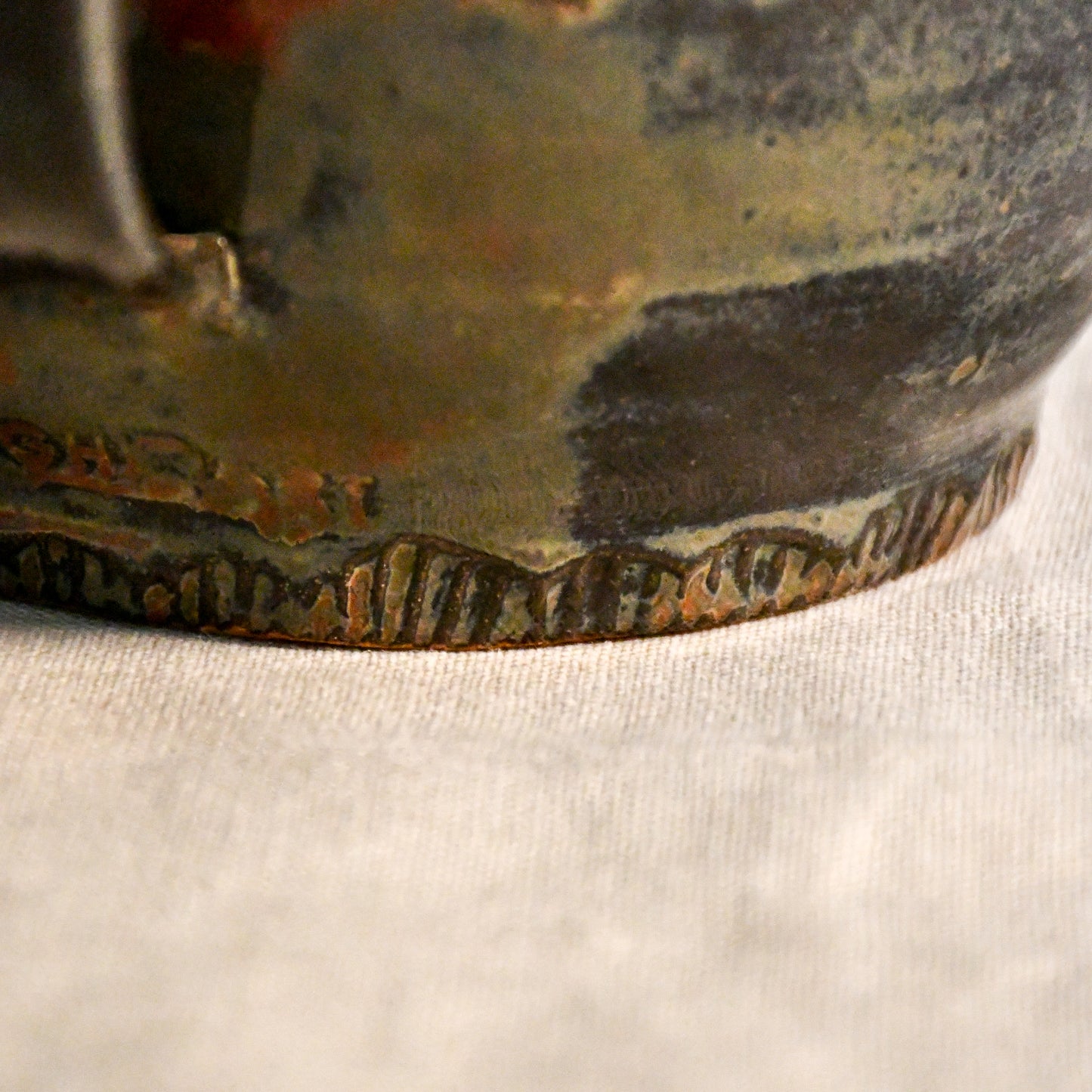 Close-up of the Ancient Jasper glaze on a handmade ceramic teapot, showcasing glossy layers of bronze, olive green, black, and deep rust tones.