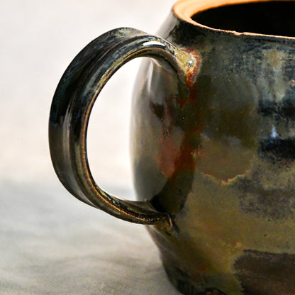 Close-up of the Ancient Jasper glaze on a handmade ceramic teapot, showcasing glossy layers of bronze, olive green, black, and deep rust tones.
