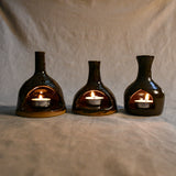 Lit handmade countertop chimineas, wheel thrown, hand-carved, fit for a tea lights and glazed in Coffee Bean glaze. 