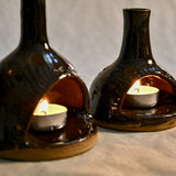 Lit handmade countertop chimineas, wheel thrown, hand-carved, fit for a tea lights and glazed in Coffee Bean glaze. 
