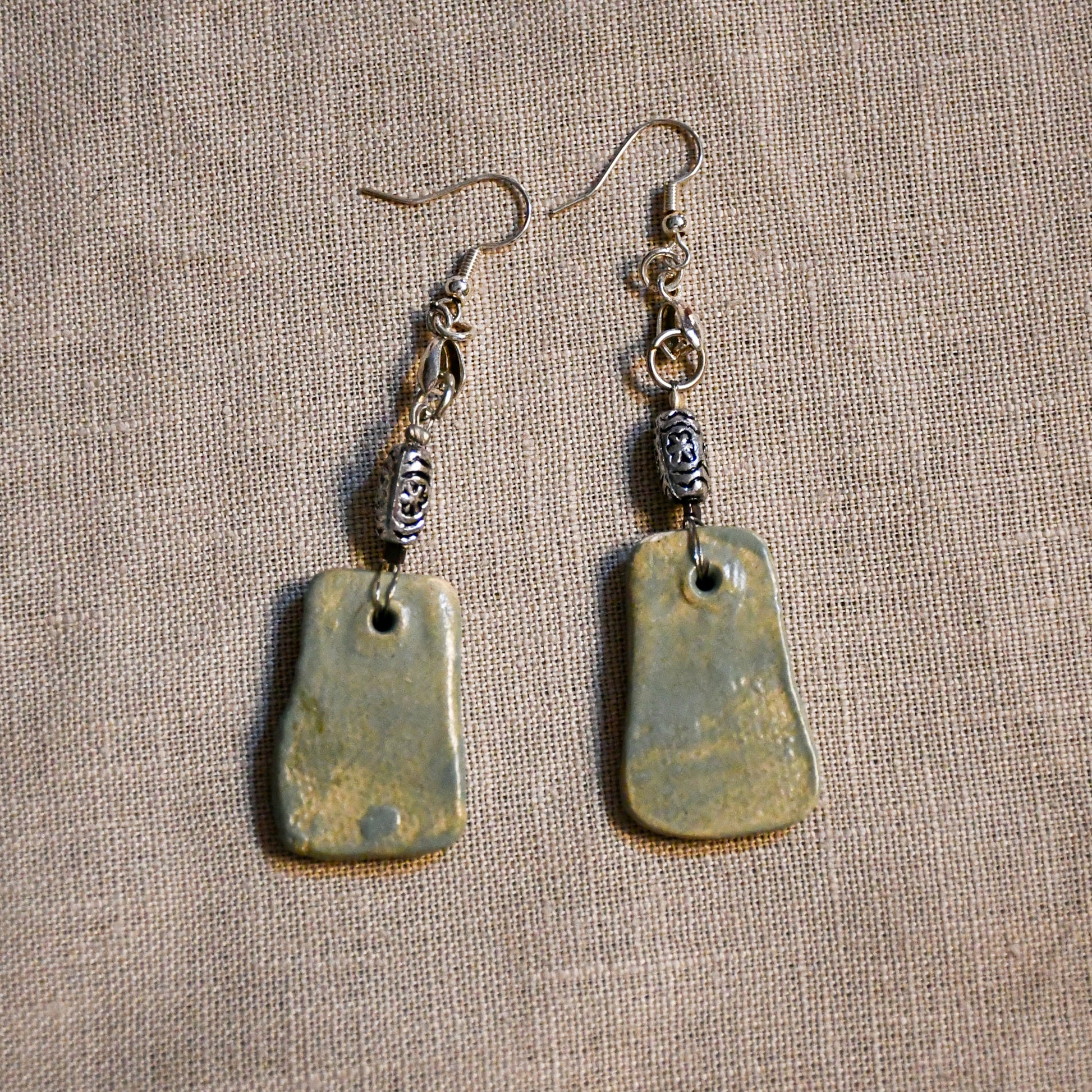 Handmade ceramic dangle earrings by Leigh Art with a modern boho silhouette.